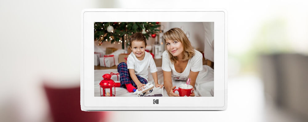 Ramka cyfrowa KODAK RCF-106 Biały prezentacja ramki ze zdjęciem na rozmazanym tle pokoju