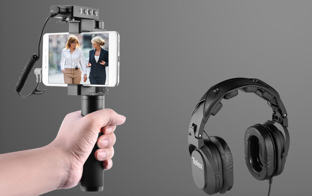 Zestaw bezprzewodowy COMICA BoomX-D D2 prezentacja urządzenia podłączonego do telefonu ręka trzymająca uchwyt z telefonem obok czarne słuchawki szare tło 
				monitorowanie dźwięku w czasie rzeczywistym kontrola jakości nagrania mikrofon komfort pracy