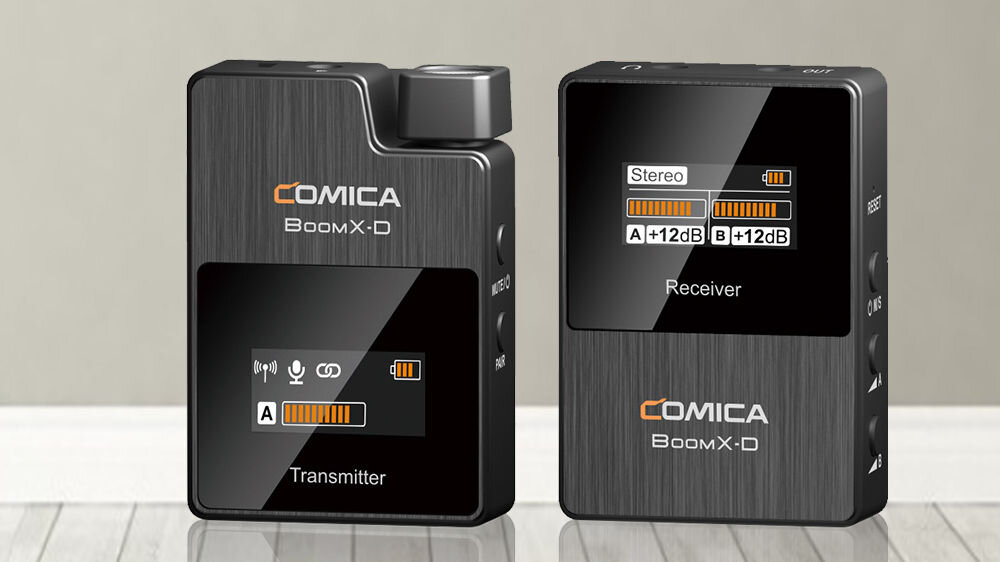Zestaw bezprzewodowy COMICA BoomX-D D2 prezentacja nadajnika i odbiornik od przodu na tle szaro-beżowej ściany 
				ekran kontrola parametrów poziom sygnału bateria kanały