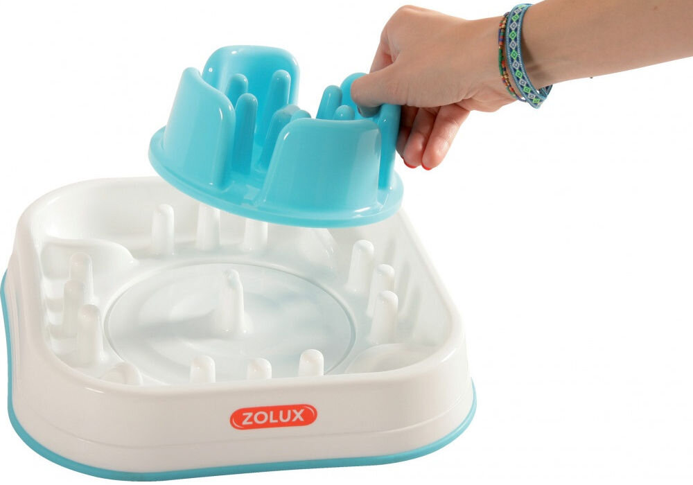 Miska spowalniająca dla psa i kota ZOLUX 474144 Biała miska spowalniająca dla zwierząt z niebieskimi elementami, wypełniona suchą karmą, z widocznym logo ZOLUX na czerwonym tle. Miska ma nieregularny kształt z kilkoma przegródkami i przezroczystymi kopułkami