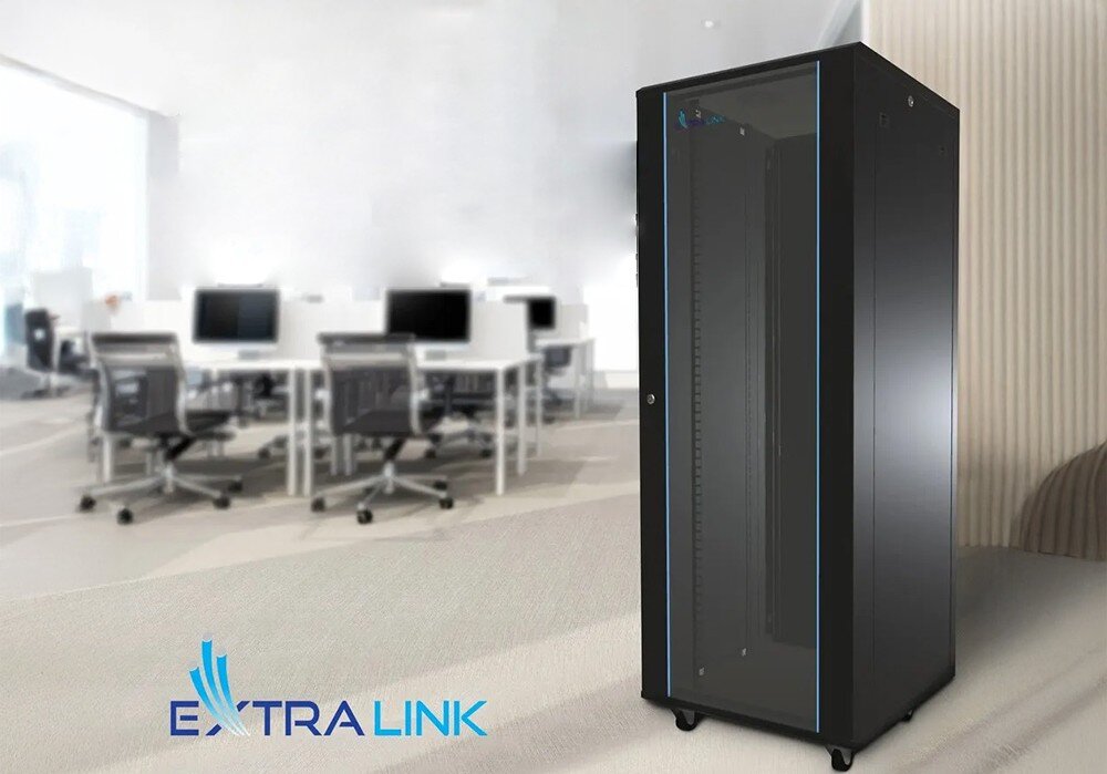 Szafa RACK EXTRALINK 19 42U EX.8628 600 x 800 mm Czarna szafa rackowa z przeszklonymi drzwiami stoi w jasnym biurze z biurkami, monitorami i krzesłami obrotowymi w tle, w lewym dolnym rogu widoczne logo 'Extralink'