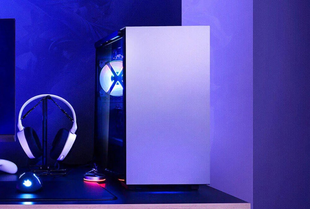 Obudowa DEEPCOOL Macube 110 WH Obudowa komputera stacjonarnego z przeszklonym bokiem i wentylatorami z podświetleniem RGB, na biurku obok stojaka ze słuchawkami i myszki podświetlonych na niebiesko