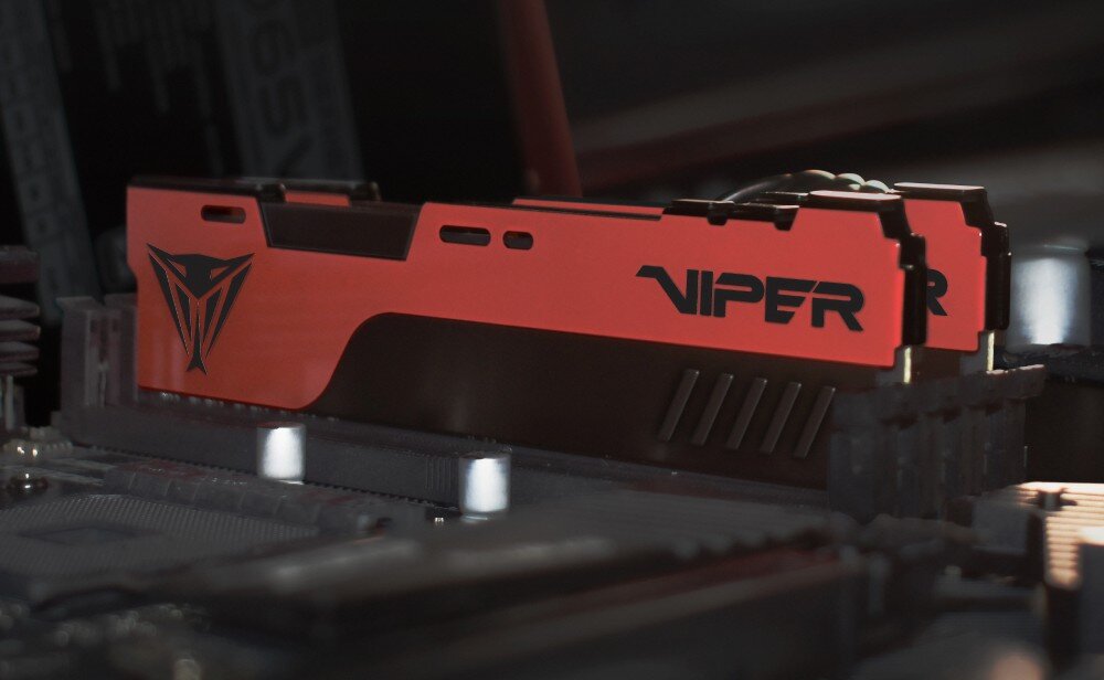 Pamięć RAM PATRIOT Viper Elite II Dwa moduły pamięci RAM z czerwonymi i czarnymi elementami obudowy zamontowane w gniazdach płyty głównej komputera, ujęcie pod kątem skupiające się na bocznej stronie z czarnym napisem 'VIPER' i logo