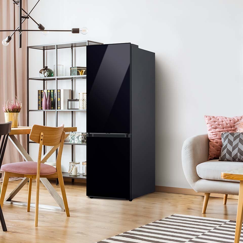 Głęboka czerń chłodziarko-zamrażarki Samsung BESPOKE w ciekawy sposób kontrastuje z bielą ścian w pokoju dziennym. Głęboka czerń chłodziarko-zamrażarki Samsung BESPOKE w ciekawy sposób kontrastuje z bielą ścian w pokoju dziennym.