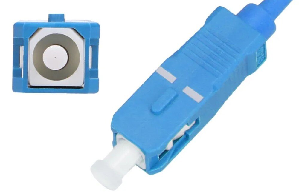 Kabel Pigtail - SC/UPC EXTRALINK EX.1940 2 m Dwa ujęcia niebieskiego złącza światłowodowego: widok od strony czołowej pokazujący kwadratowy przekrój z białym punktem w środku oraz widok pod kątem prezentujący obudowę z białą nasadką na końcu