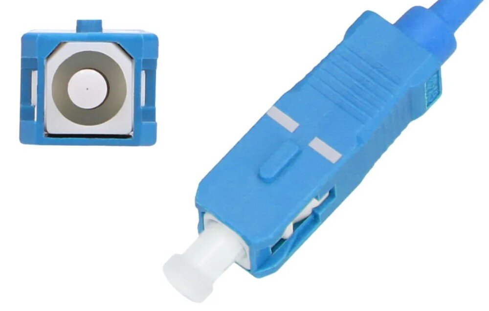 Kabel Pigtail - SC/UPC EXTRALINK EX.3319 Zbliżenie na niebieskie złącze światłowodowe w dwóch ujęciach: widok od strony czołowej pokazujący kwadratowy przekrój z białym środkiem oraz widok pod kątem prezentujący obudowę z białą zatyczką ochronną