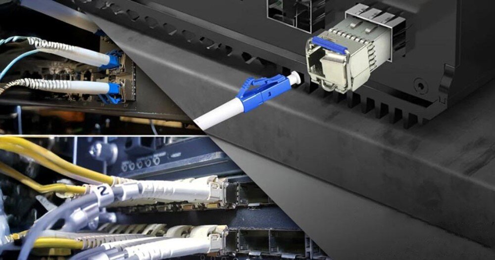 Wkładka SFP EXTRALINK EX.6211 (2 szt.) Zbliżenie na podłączone do urządzenia sieciowego przewody światłowodowe z niebieskimi złączami LC oraz metalowe moduły SFP osadzone w portach sprzętu sieciowego