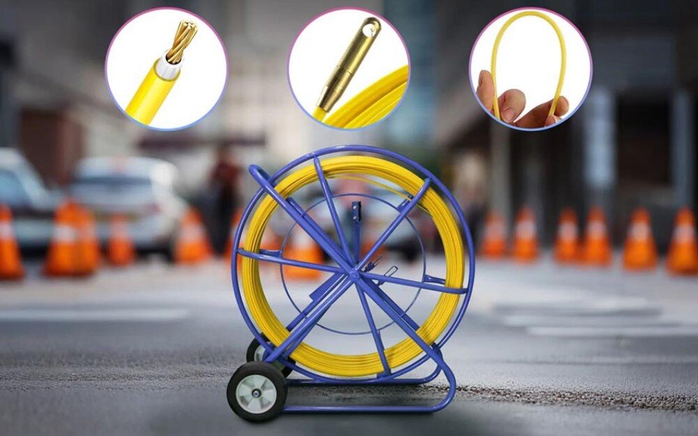 Pilot do przeciągania kabli EXTRALINK EX.13919 Niebieski stojak z żółtym przewodem ustawiony na ulicy z pachołkami drogowymi w tle, z trzema okrągłymi zbliżeniami pokazującymi szczegóły końcówki, przekroju i elastyczności przewodu