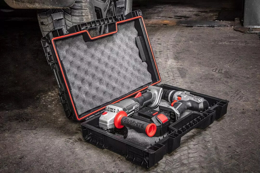 Walizka narzędziowa GRAPHITE 58GE102 podłoga ziemia otwarta walizka wypełniona narzędziami w tle opony bezpieczny transport praktyczne zastosowanie przenoszenie przechowywanie mobilność
