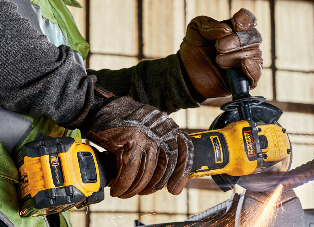 Szlifierka kątowa DEWALT DCG409NT osoba używa szlifierki tnie metalową rurkę zabezpieczone siatką otwory wlotowe powietrza długa żywotność silnika zmniejsza potrzebę serwisowania lekka waga 1,81 kg niewielka konstrukcja