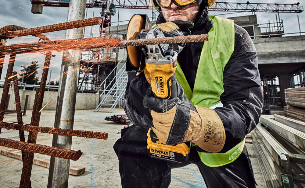 Szlifierka kątowa DEWALT DCG409T1 pokrywa siatkowa nad wlotami powietrza ogranicza zasysanie pyłu przez silnik