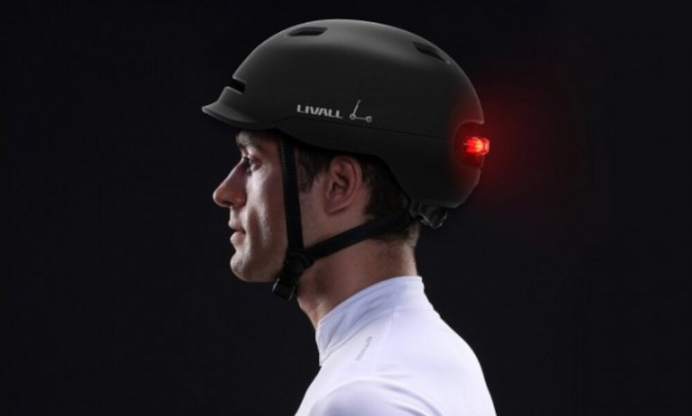 Kask LIVALL C20 Czarny (rozmiar L) ciemne tło osoba w kasku widoczna z boku funkcja automatycznego uśpienia i wzbudzenia oszczędzać energię system sam reaguje na brak aktywności wydłużając czas pracy klasa szczelności IPX4 chroni elektronikę przed zachlapaniem wodą