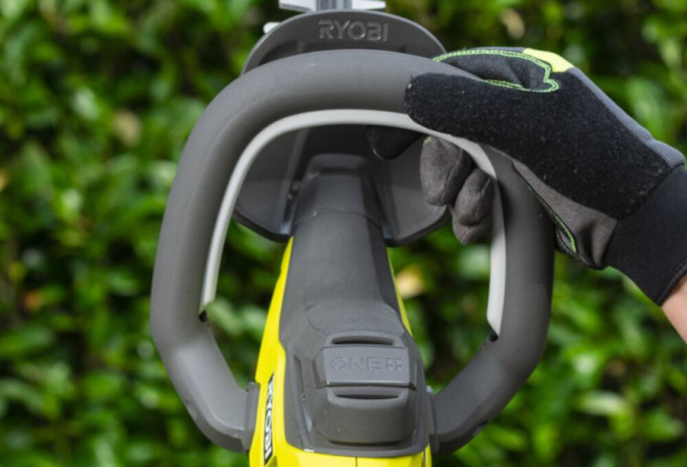 Nożyce do żywopłotu RYOBI RY18HT55A-120 550mm 18V akumulatorowe ogród zbliżenie na uchwyt w tle żywopłot uchwyt liniowy LINEA odpowiednie wyważenie lekka waga (2,4 kg) ergonomiczny kształt wspiera stabilność ruchów poprawia bezpieczeństwo równa linia cięcia