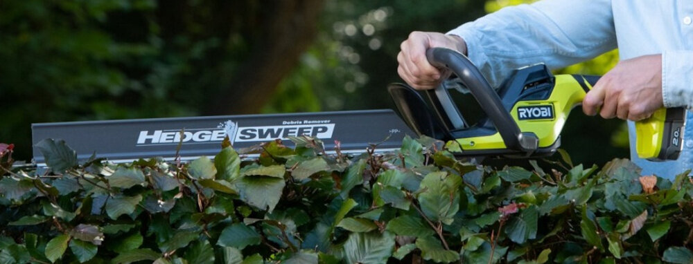 Nożyce do żywopłotu RYOBI RY18HT55A-120 550mm 18V akumulatorowe ogród osoba przycina żywopłot zbliżenie na nasadkę nasadka HedgeSweep™ bieżące usuwanie ścinków z powierzchni żywopłotu podczas pracy porządek w ogrodzie skraca czas sprzątania poprawia komfort pracy