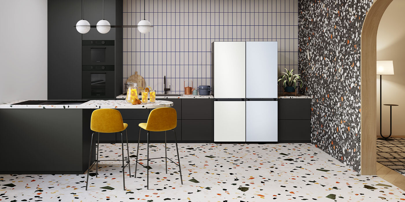 Zdjęcie pokazuje nowocześnie urządzoną kuchnię, do której wstawione zostały dwie chłodziarko-zamrażarki Samsung BESPOKE. Urządzenia połączone są w spójny system modułowy o zbliżonych kolorach.