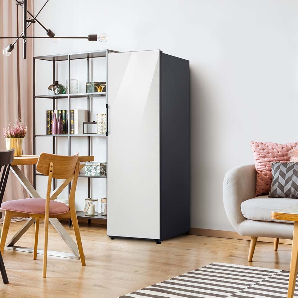 Zdjęcie stojącej w pokoju dziennym chłodziarki Samsung BESPOKE z panelem szklanym