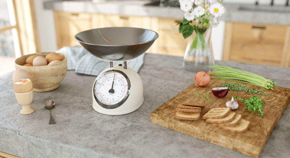 Waga kuchenna ETA Storio 577790040 precyzyjne ważenie beżowa waga stoi na blacie srebrna miska duży wskaźnik obok składniki na desce  