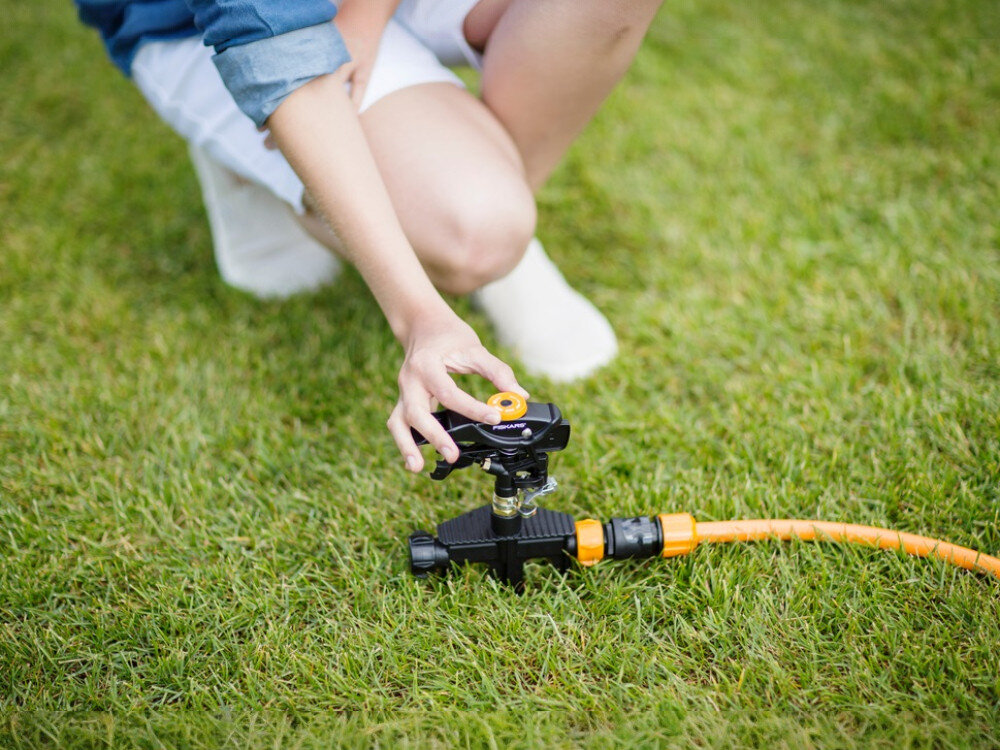 Zraszacz FISKARS 1023656, sektor, kąt, ogrodzenie, elastyczność, osoba reguluje pokrętło zraszacza