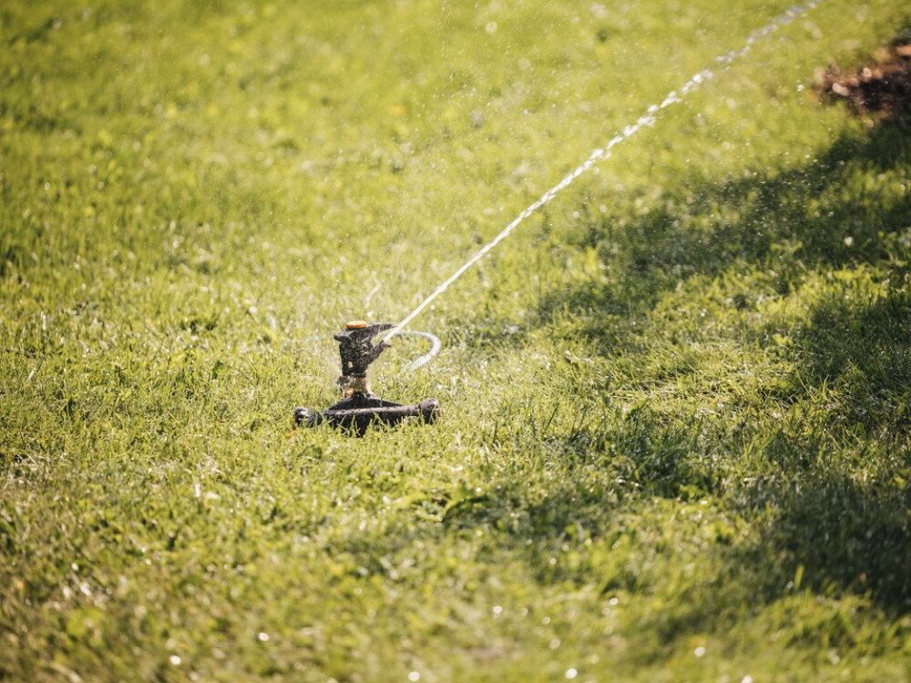 Zraszacz FISKARS 1023656, przyłącze, wąż, kompatybilność, system, zraszacz podlewa trawnik w ogrodzie podczas słonecznego dnia
