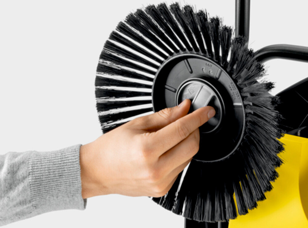 Zamiatarka ręczna KARCHER S4 Twin 2-in-1 1.766-365.0 zbliżenie na szczotkę osoba mocuje szczotkę do urządzenia mocowanie szczotek bocznych bez użycia narzędzi praktyczna nakrętka szczotki bocznej usprawnia montaż i demontaż