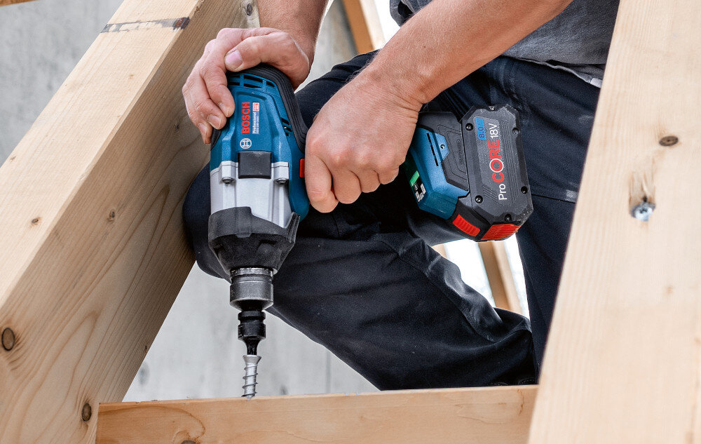 Klucz udarowy BOSCH Professional GDS 18V-1000 06019J8300 drewniana konstrukcja osoba przykręca śrubę do konstrukcji technologia BITURBO Brushless silnik bezszczotkowy przekazuje więcej energii z akumulatora na wrzeciono wyższa wydajność pracy na jednym ładowaniu mniejsze nagrzewanie podczas długich zadań mniej elementów zużywających się