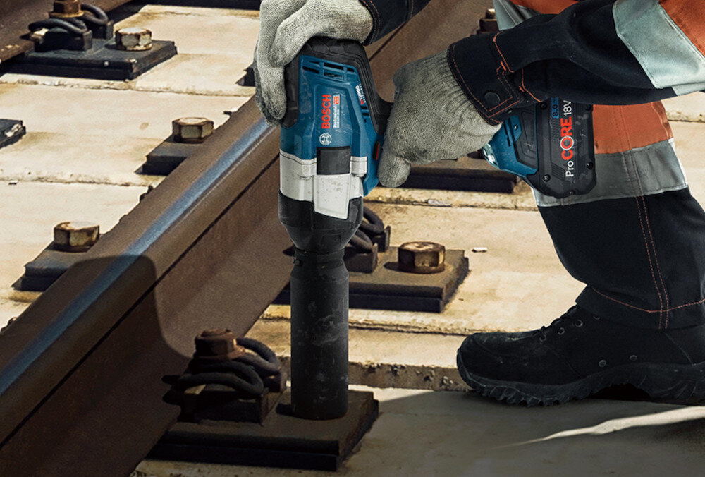Klucz udarowy BOSCH Professional GDS 18V-1000 06019J8300 tory kolejowe osoba dokręca śruby przy szynach mechanizm udarowy generuje do 2600 udarów na minutę przyspiesza luzowanie zapieczonych połączeń i skraca czas dokręcania energia udaru przenoszona jest bezpośrednio na nasadkę krótsze cykle robocze mniejsze zmęczenie rąk sprawniejsze tempo pracy