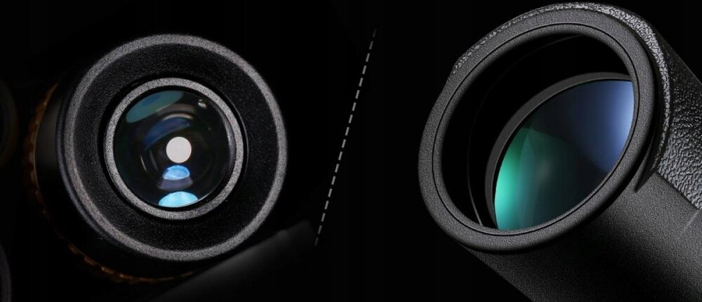 Obraz przedstawia zbliżenie na dwa obiektywy lornetki z widocznymi soczewkami. Soczewki mają różne odcienie, a obudowa jest ciemna i teksturowana.
