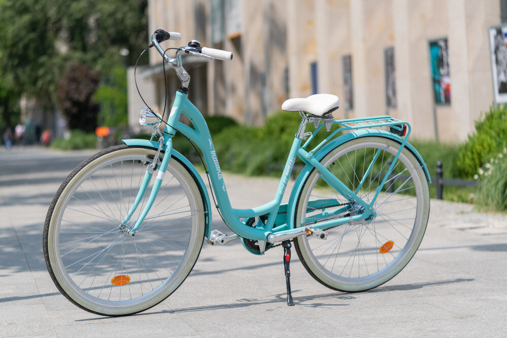 Rower miejski INDIANA Moena A7B 28 cali damski Lazurowy w lazurowym kolorze dla kobiet liczne elementy poprawiające komfort użytkowania oświetlenie na przód i na tył osłona łańcucha bagażnik retro design