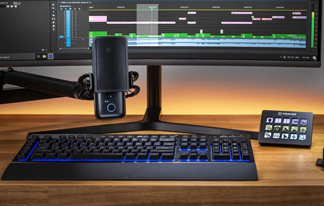 Stanowisko z monitorem, mikrofonem i klawiaturą prezentuje panel Elgato Stream Deck ustawiony na drewnianym biurku - Profile dla różnych aplikacji i zastosowań 