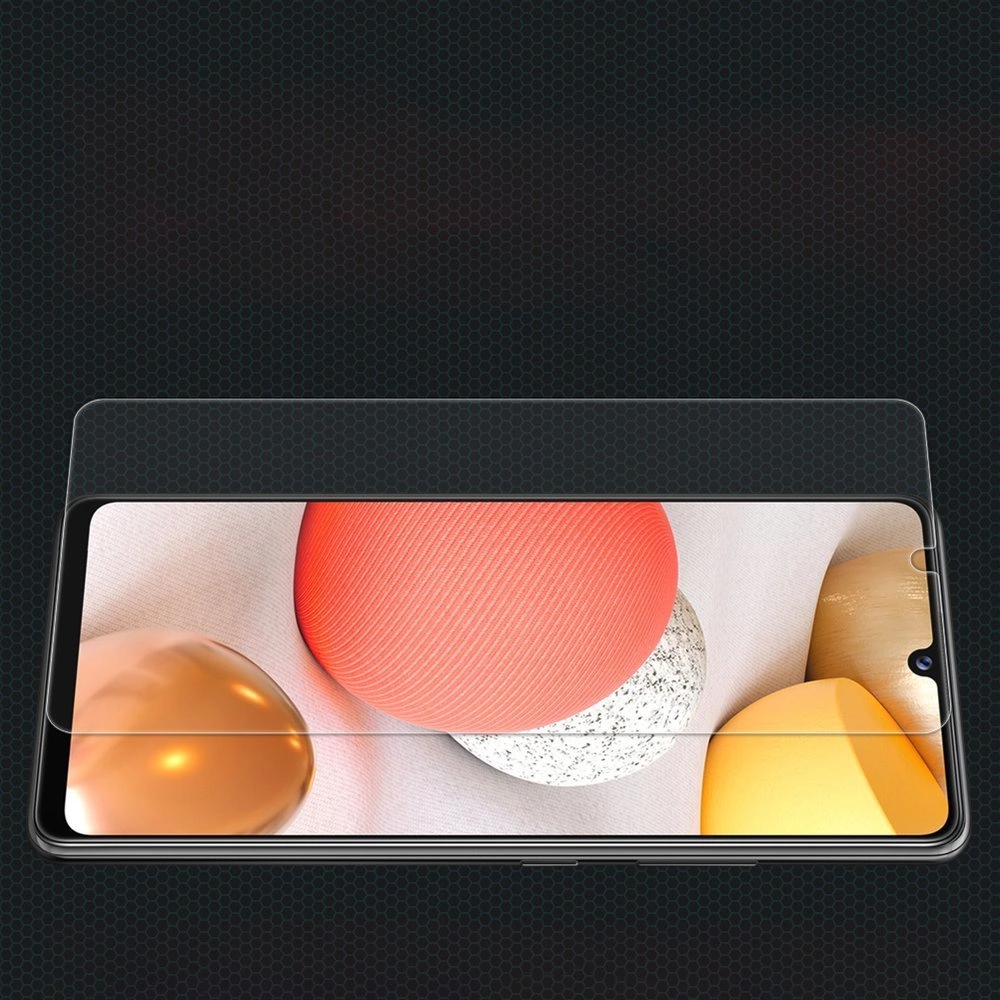 Obraz przedstawia smartfon z nałożonym szkłem ochronnym, na ekranie widoczne są kolorowe kształty. Tło jest ciemne z delikatnym wzorem siatki.