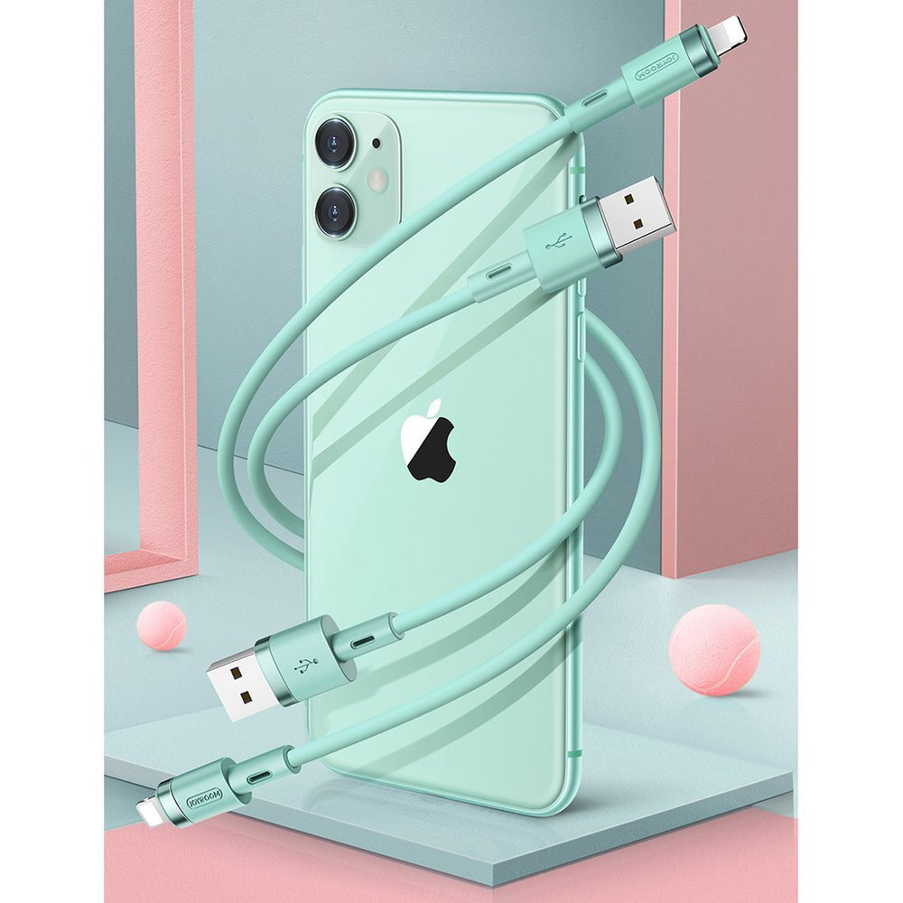 Na obrazie widać miętowy kabel USB/Lightning owinięty wokół miętowego smartfona z logo jabłka. W tle znajdują się różowe i szare geometryczne kształty oraz różowa piłeczka.