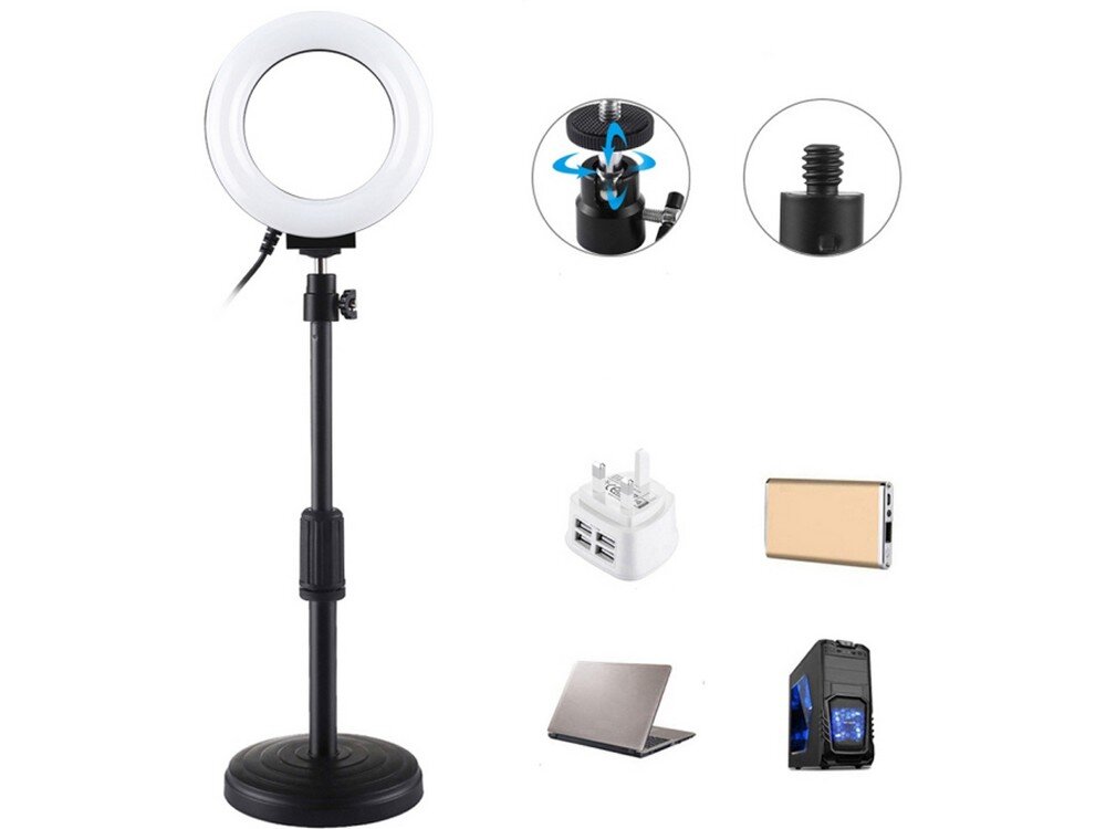Na obrazie znajduje się lampa pierścieniowa LED na regulowanej podstawce. Obok lampy widoczne są różne akcesoria, takie jak adapter USB, powerbank, laptop i komputer stacjonarny.