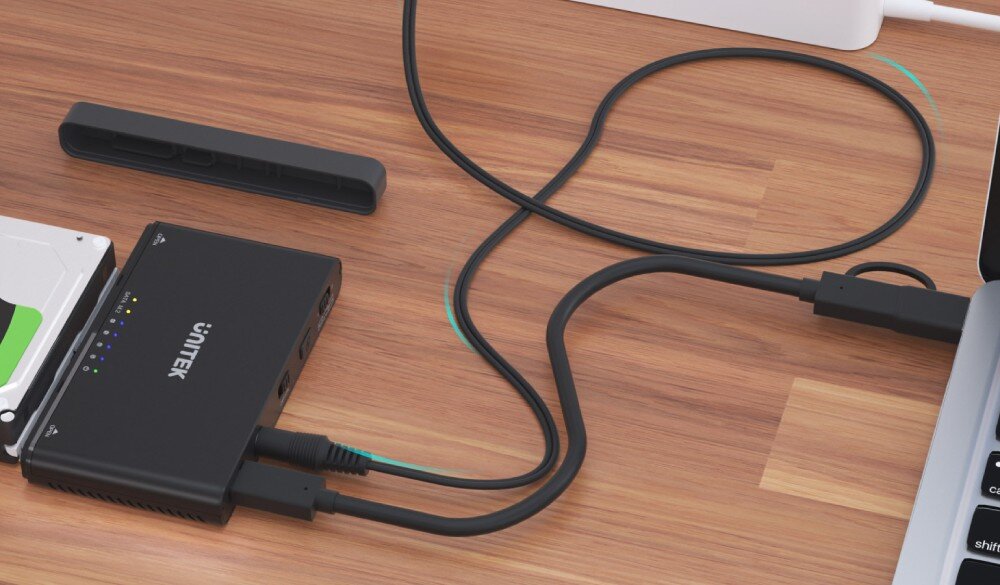 Stacja dokująca UNITEK S1222A Urządzenie połączone kablem USB z laptopem oraz dyskiem HDD na biurku