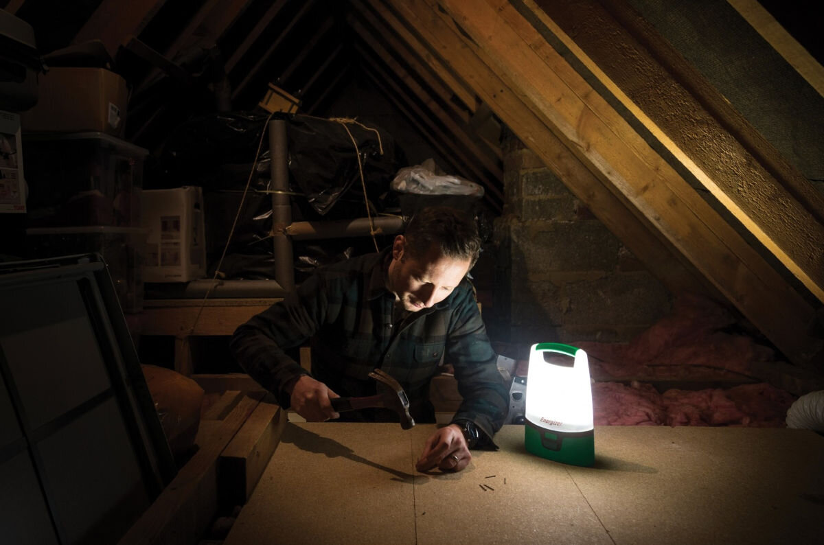 Latarka ENERGIZER Lanteharn Recrgeable, światło, oświetlenie, lampka, pomoc, osoba oświetla miejsce pracy na strychu dzięki latarce