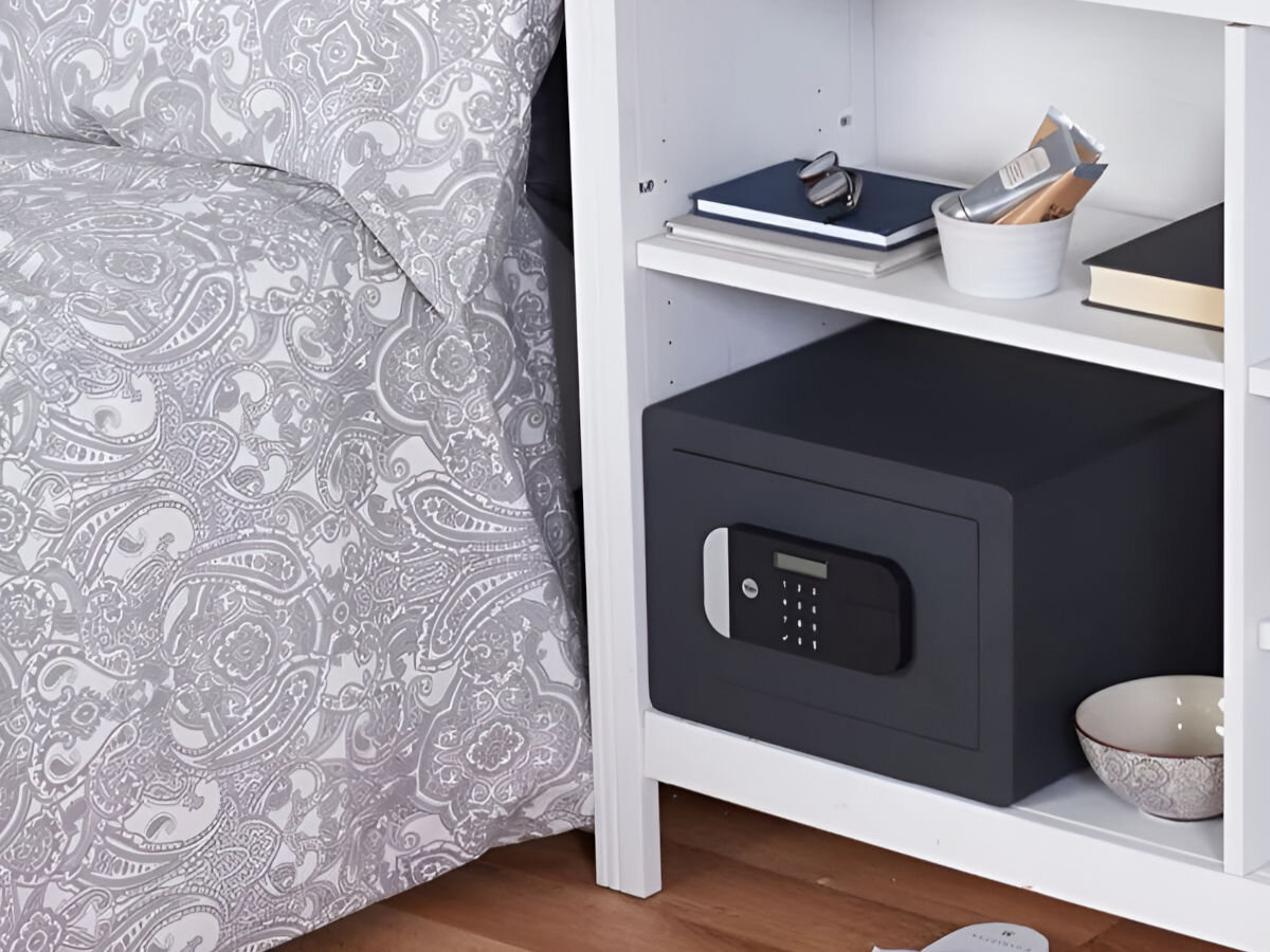 Sejf YALE YSEM 250 EG1, waga, wymiary, pojemność, konstrukcja, sejf stoi na szafce nocnej obok łóżka