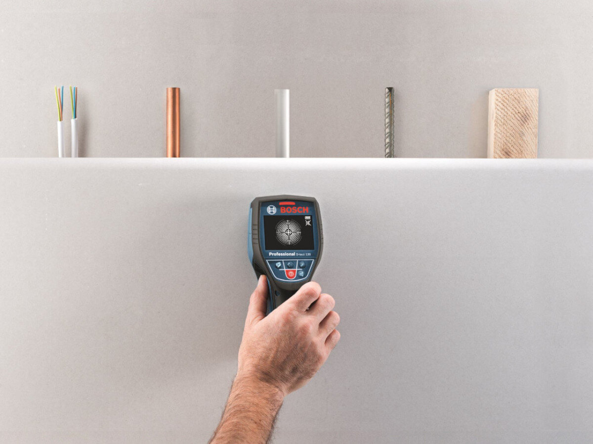 Detektor BOSCH Professional D-Tect 120 0601081308, dioda LED, alarm, rury, sygnał, dłoń trzyma detektor do ściany z wizualizacją rur