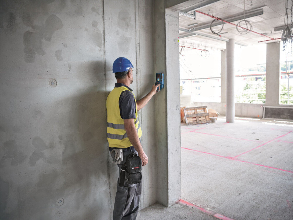 Detektor BOSCH Professional D-Tect 200 C 0601081608, mur, skan, detekcja, budowa, Budowlaniec skanuje betonową konstrukcję detektorem Bosch.