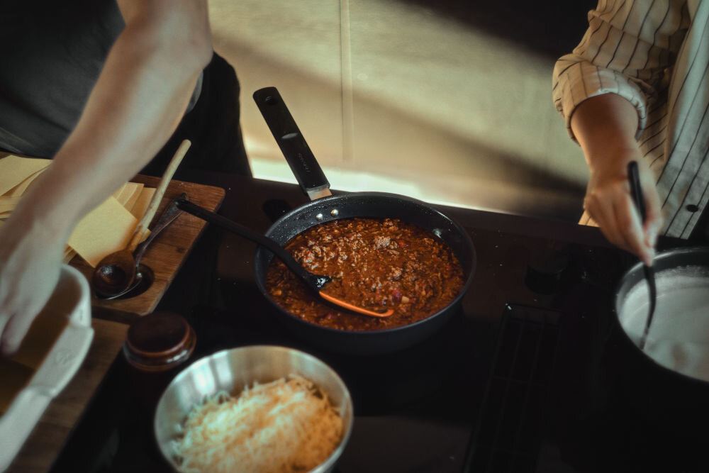 Patelnia FISKARS Hard Face 1052232 28 cm czarna patelnia stoi na płycie potrawa na patelni  średnica 28 cm pojemność 3,5 l dla wymagających kucharzy codzienne intensywne gotowanie smażenie duszenie dania jednogarnkowe przezroczysta pokrywka z hartowanego szkła funkcja odcedzania 