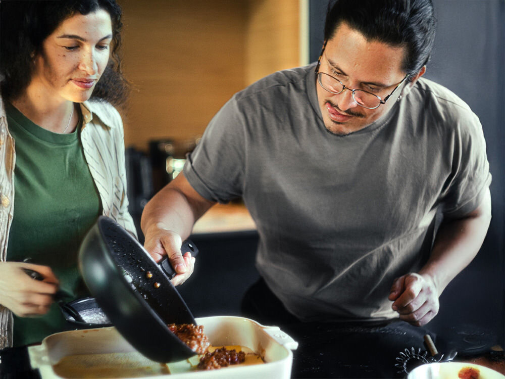 Patelnia FISKARS Hard Face 1052232 28 cm osoba przekłada potrawę z czarnej patelni maksymalna efektywność cieplna technologia Energy Base do 50% szybciej do 30% mniej energii indukcyjne gazowe elektryczne konwekcyjna ceramiczne kuchenki   