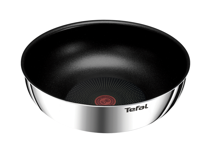 Na obrazie widoczna jest patelnia wok z czarnym wnętrzem i srebrnym wykończeniem zewnętrznym. Na boku znajduje się logo \'Tefal\'.