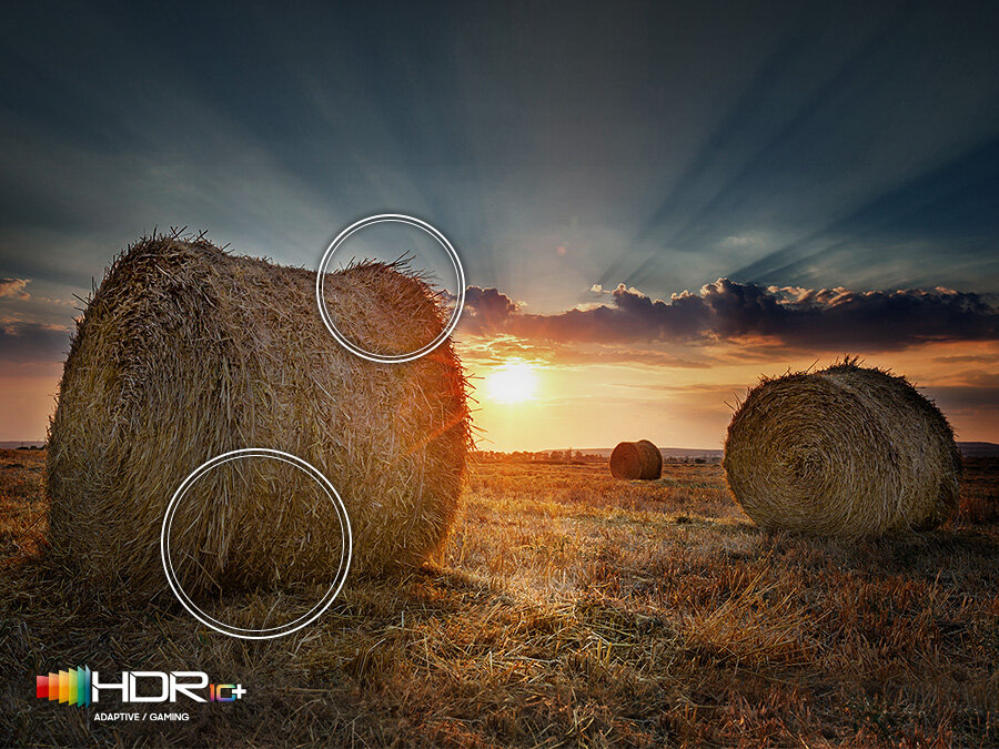 Солнце, садящееся над прерией, демонстрирует улучшенную контрастность технологии Quantum HDR.  На дисплее есть логотип HDR10+.  Q77BATXXH