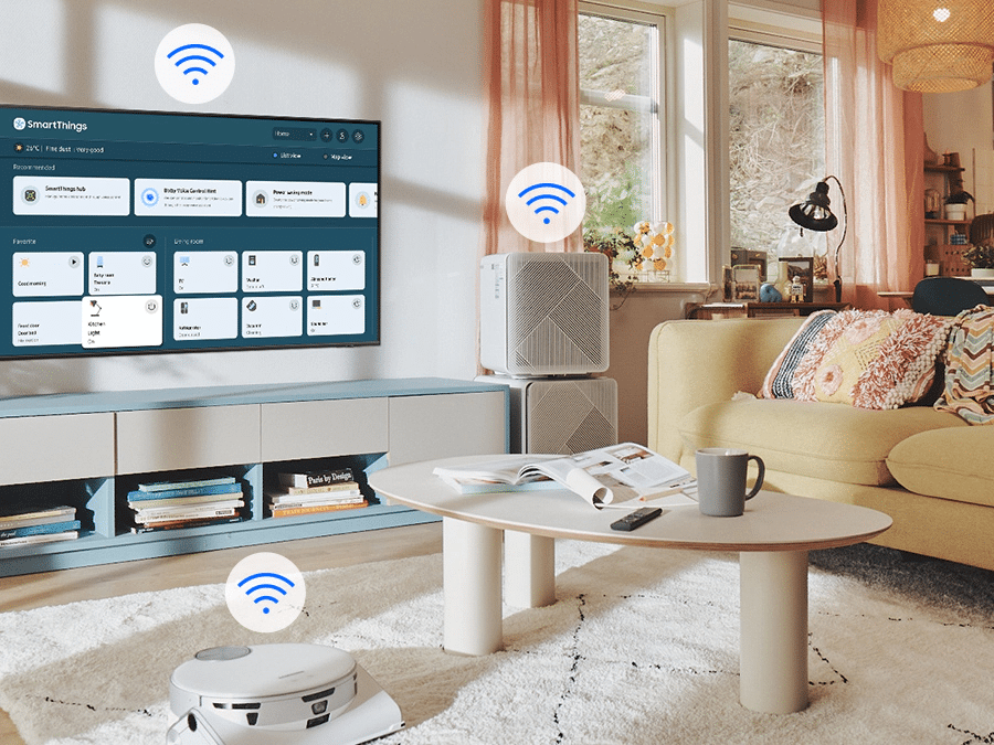 Na ekranie telewizora widać menu SmartThings. Ikonki WiFi pokazane nad telewizorem, odkurzaczem samojezdnym i oczyszczaczem powietrza. Na ekranie telewizora widać menu SmartThings. Ikonki WiFi pokazane nad telewizorem, odkurzaczem samojezdnym i oczyszczaczem powietrza.