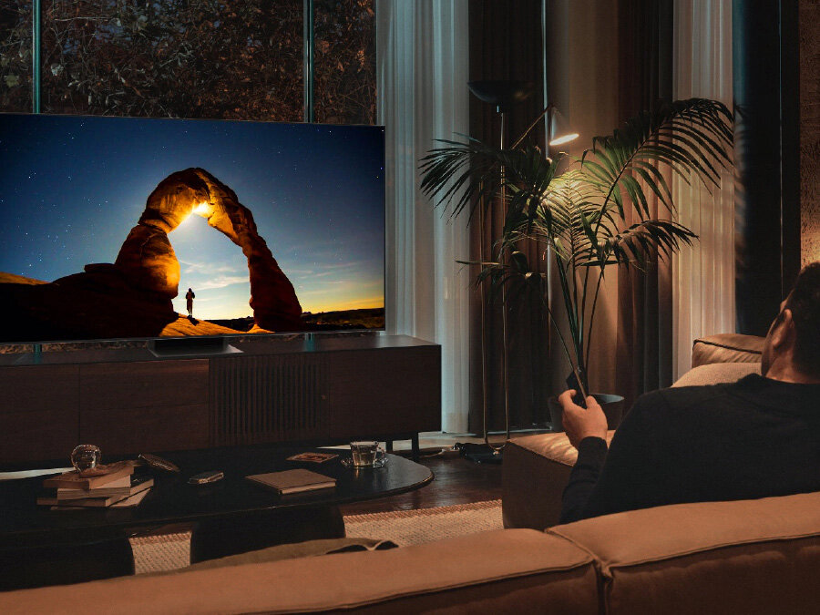 phpmbhmbp pl-feature-intelligent-picture-optimized-for-your-eye-531081139 Mężczyzna przed telewizorem QLED w nocy. Ekran wyświetla obraz zoptymalizowany w Trybie Komfortu dla Oczu.