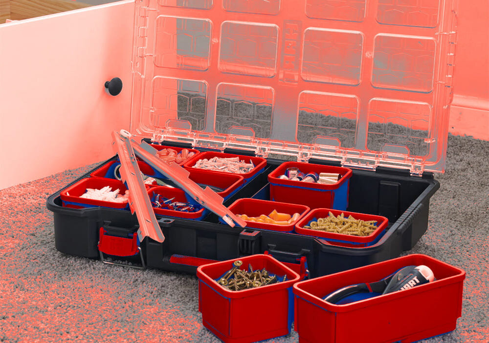 Organizer KETER 251491 dywan otwarty organizer stoi na dywanie wnętrze przegródki wypełnione różnymi akcesoriami porządek wygodne przechowywanie