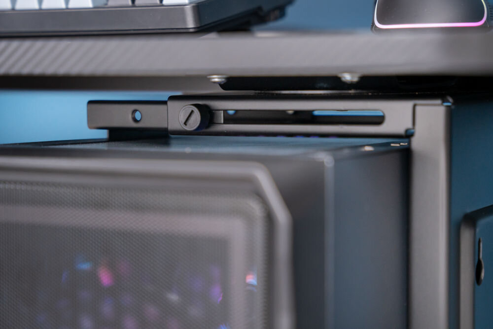 Uchwyt biurkowy do obudowy PC ART M-01 Zbliżenie na mechanizm regulacji szerokości uchwytu biurkowego na komputer. Widoczna jest śruba pozwalająca na dopasowanie uchwytu do rozmiaru obudowy komputera.