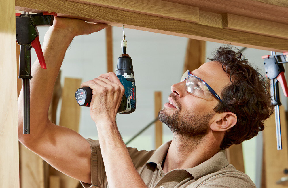 Wiertarko-wkrętarka BOSCH Professional GSR 12V-35 FC 06019H3000 pomieszczenie osoba przykręca drewnianą deskę do deski zasilane przez akumulator Li-Ion 12 V stabilna moc brak efektu pamięci w zestawie dwa akumulatory o pojemności 3,0 Ah ładowarka wskaźnik stanu naładowania kompatybilność ze wszystkimi bateriami i ładowarkami BOSCH Professional 12 V