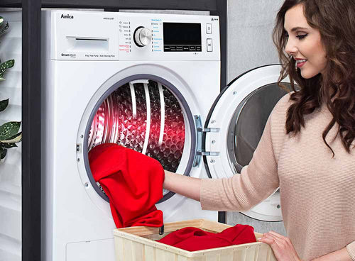 Kobieta przy suszarce wyciągająca czerwony materiał