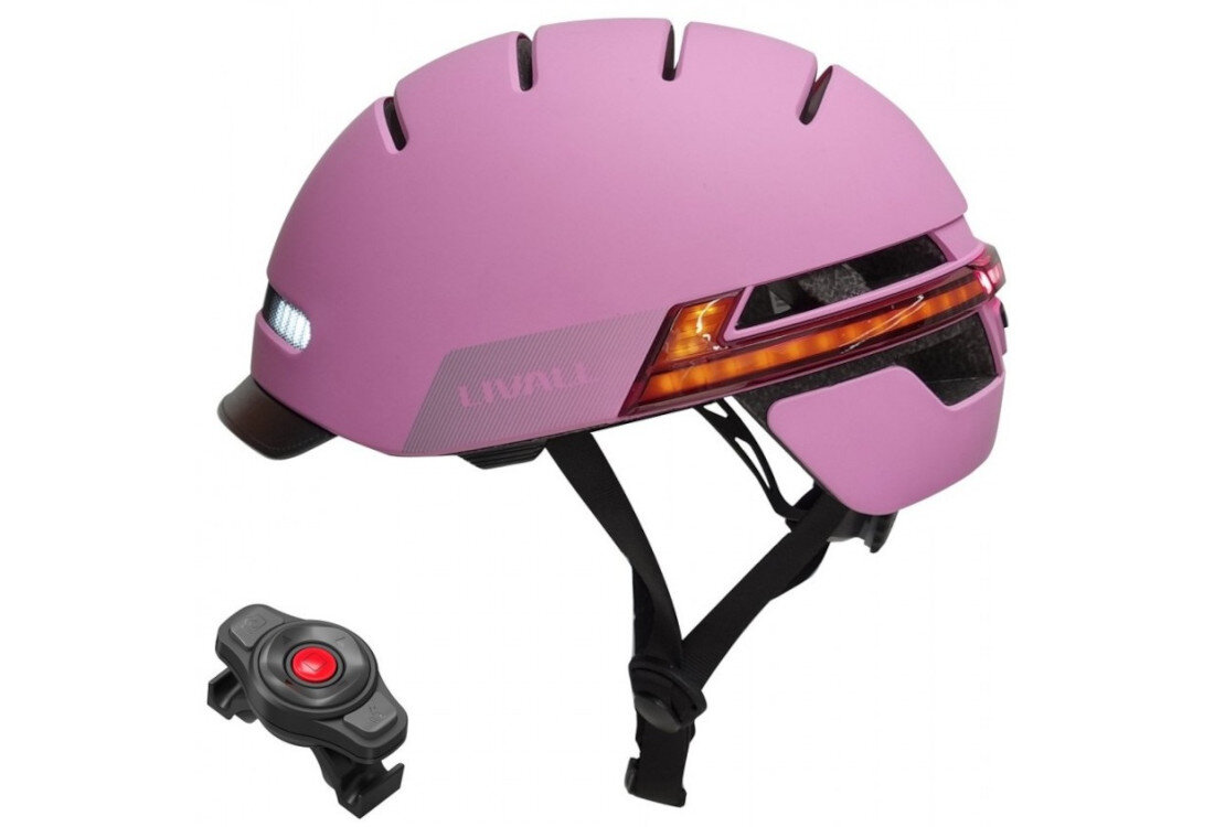 Różowy kask z lampką, posiadający czarne paski i elementy odblaskowe. Obok kasku znajduje się czarny pilot z czerwonym przyciskiem.