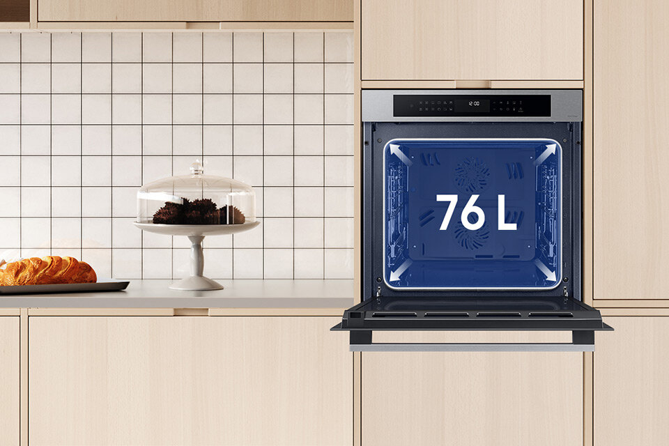 Zdjęcie przedstawiająca piekarnik parowy Samsung Dual Cook, który został wstawiony do pomieszczenia kuchennego urządzonego w beżowych kolorach.