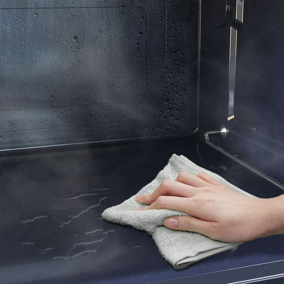 Przecieranie ściereczką wnętrza kuchenki pokazane na ilustracji Przecieranie ściereczką wnętrza kuchenki pokazane na ilustracji